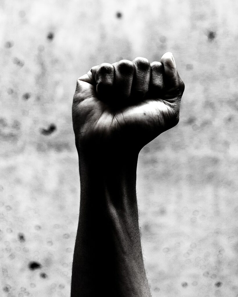 A balck and white of a fist clenched in fear of letting go and allowing.