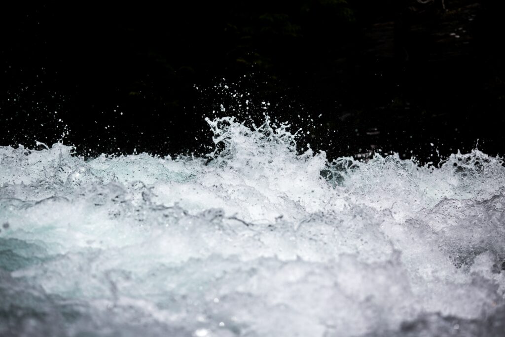 The turbulent white waters of a river rapid representing author's crisis of faith in her country