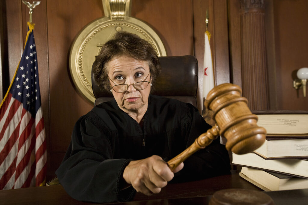 A female judge with a gavel conveying the judgment you can let go of when you quit taking it personally