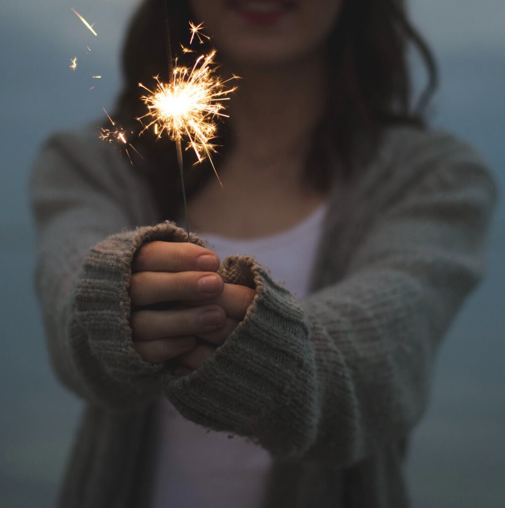 A woman holds a sparkler that lights up the path when you name and claim your superpower