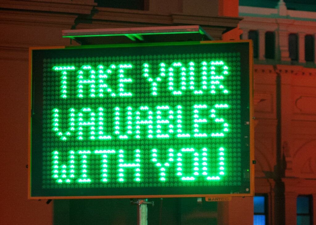 A green construction sign that says "take your valuables with you" related to important message of the value of self care.
