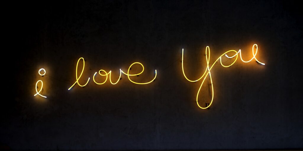 a deglow yellow electric sign spelling lower case "I love you"