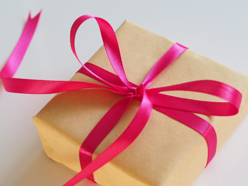 A gift wrapped in brown parchment paper reflecting and bright pink ribbon reflecting the gift parents find  by making it a dance of homeschooling.