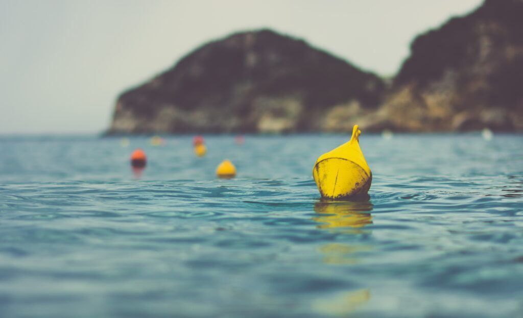 Several buoys in the water representing the lifting of spirit with surrender, faith, compassion, and stillness