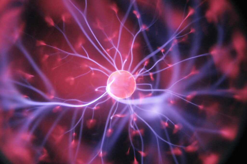 Bright red center ball like an atom or neuron with powerful white tentacles extending out in many directions.