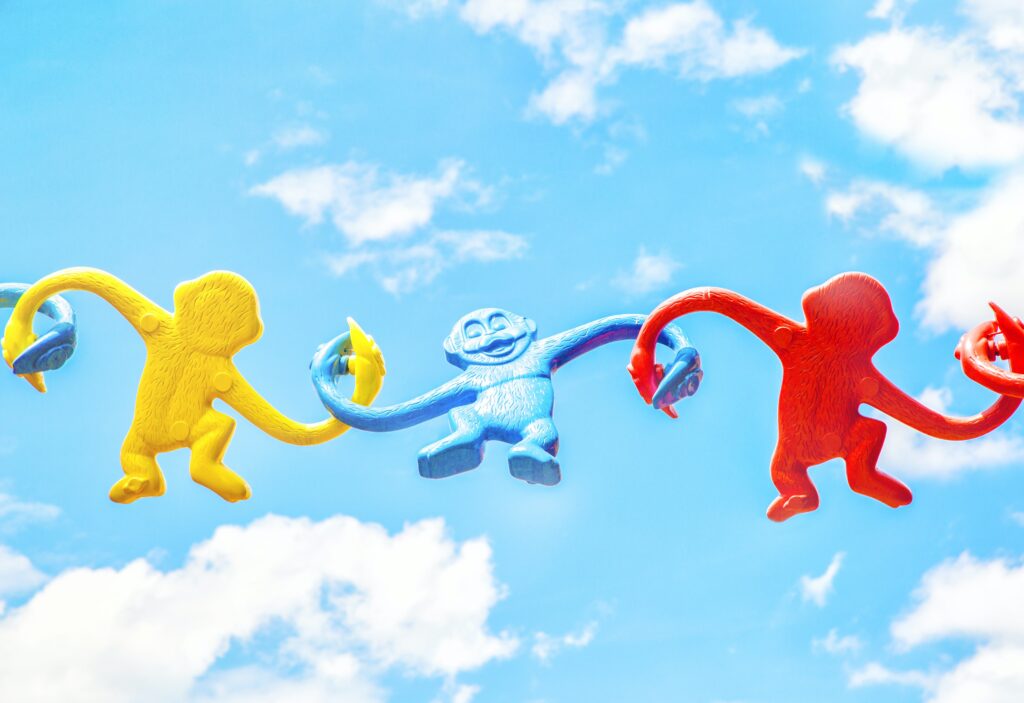 Multi-color plastic monkeys playfully hooked arm in arm much like we need to be helping our children cope!