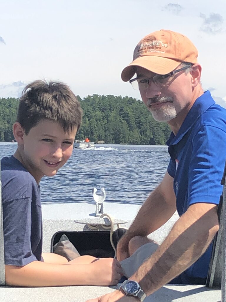Celebrating dads: a picture of the author’s husband and their son on a boat on a lake.