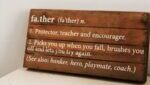 A wooden placard celebrating dads with the definition of “father”