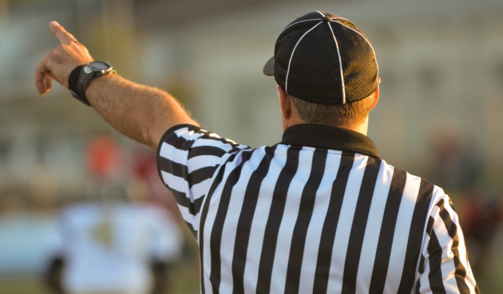 A referee making a call on an interaction on the field. 