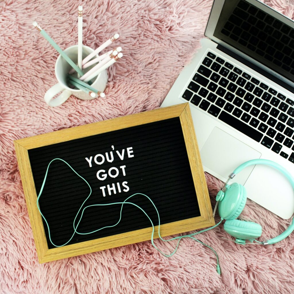 A laptop, writing utensils, headphones and a board that says “you’ve got this” referring the hardest final steps of bouncing back from hard times.