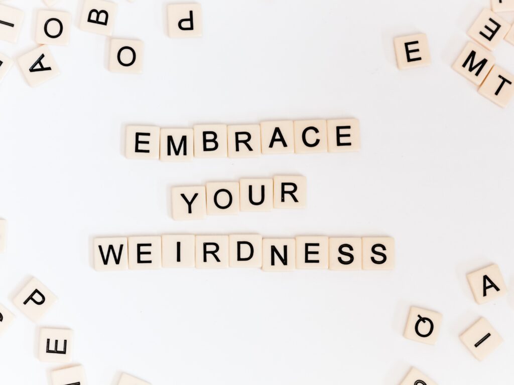 Scrabble letters laid out to spell “embrace your weirdness”