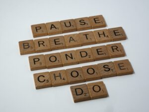 The words, Pause, breathe, ponder, choose and do stacked as scrabble words
