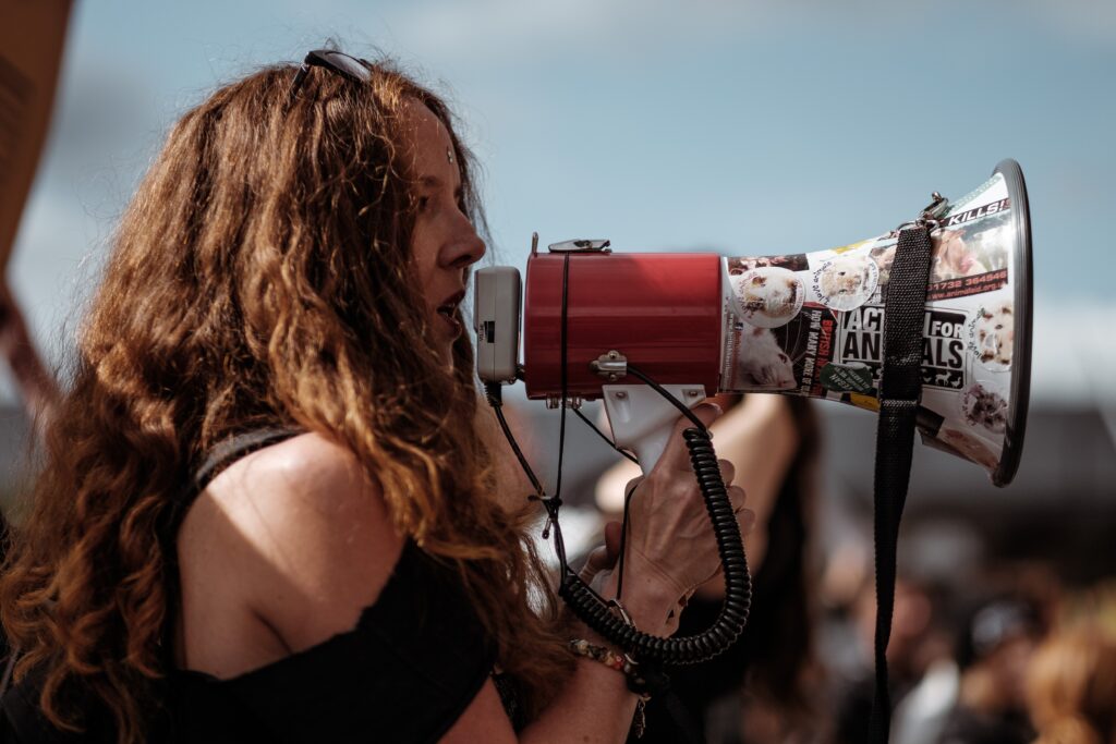 Women with a megaphone broadcasting her title and message